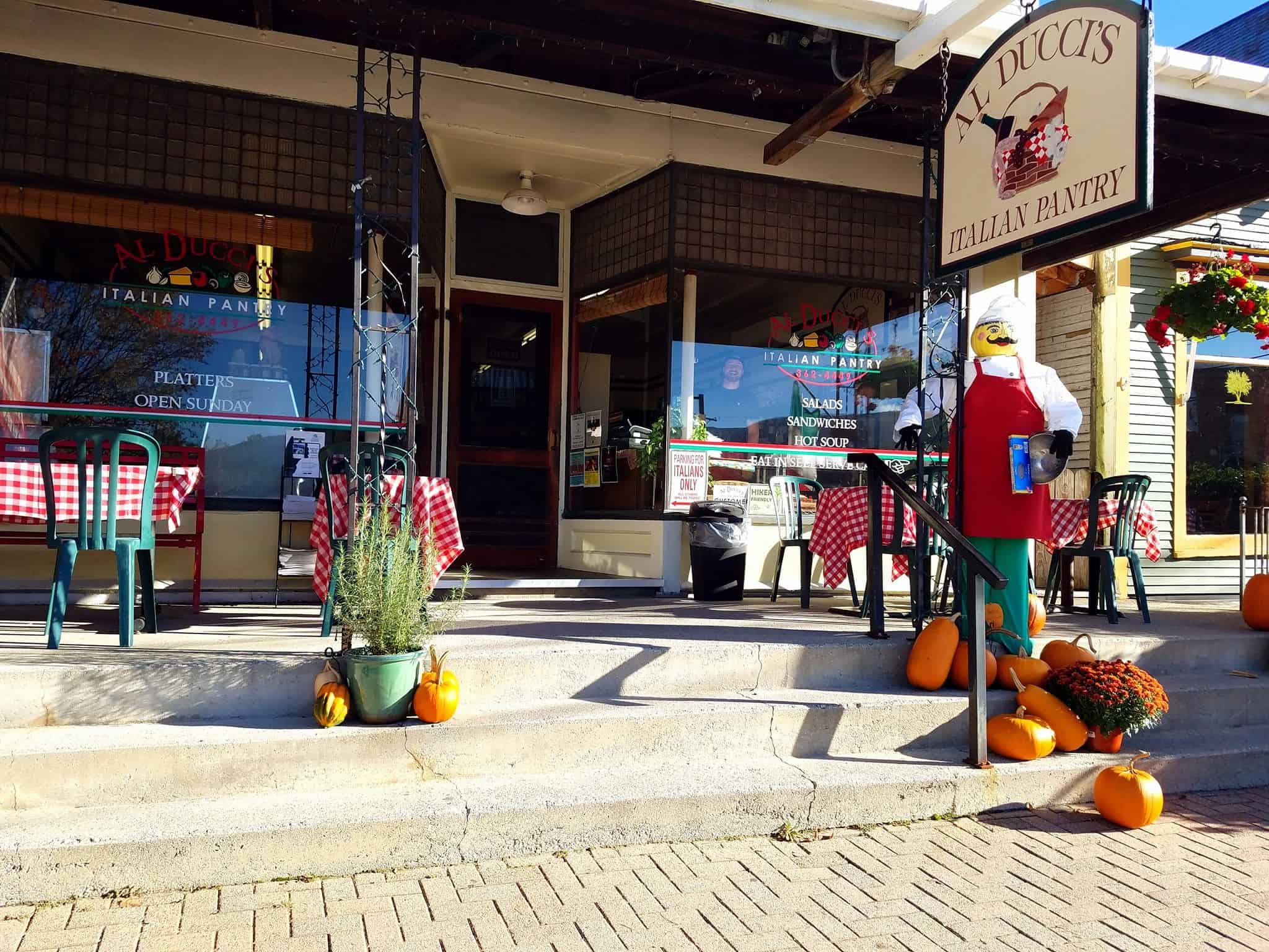 Al Duccis - Exterior Entrance with Sign and Tables